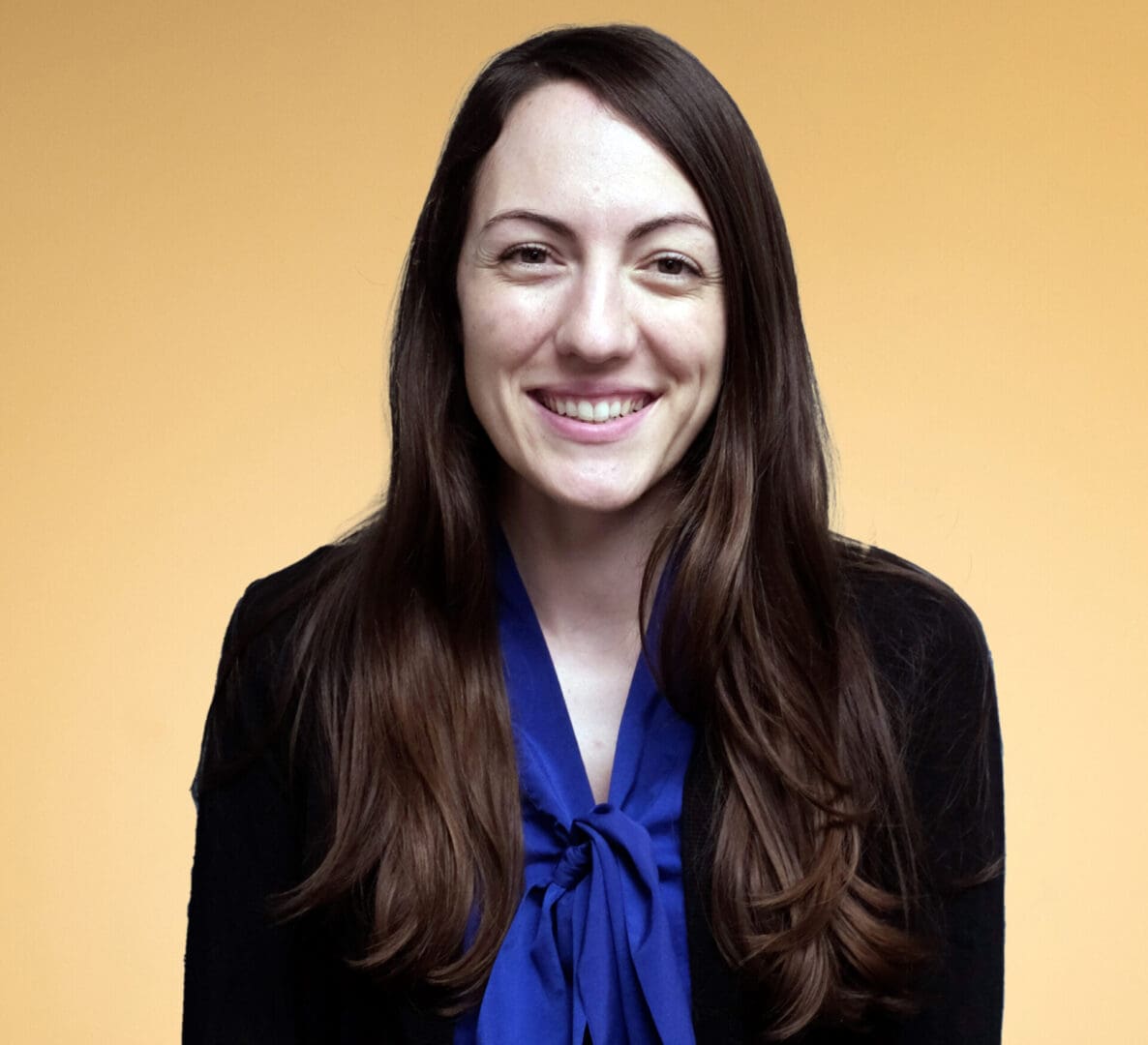 A woman in a blue top and a dark suit jacket