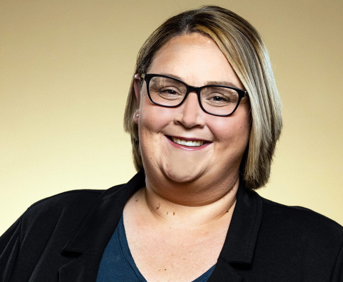 A smiling blonde woman in glasses