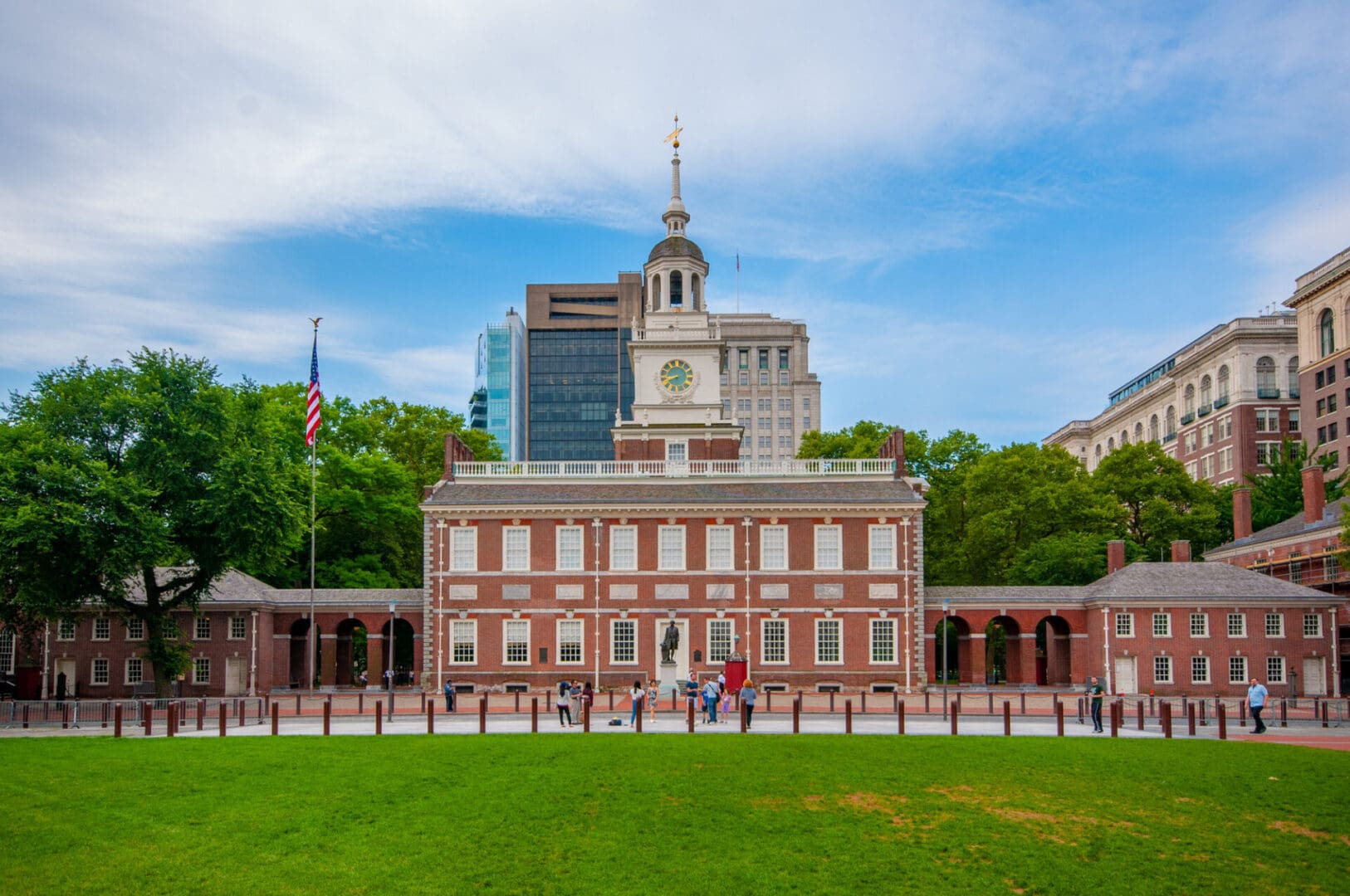 Historic building with clock tower and lawn.